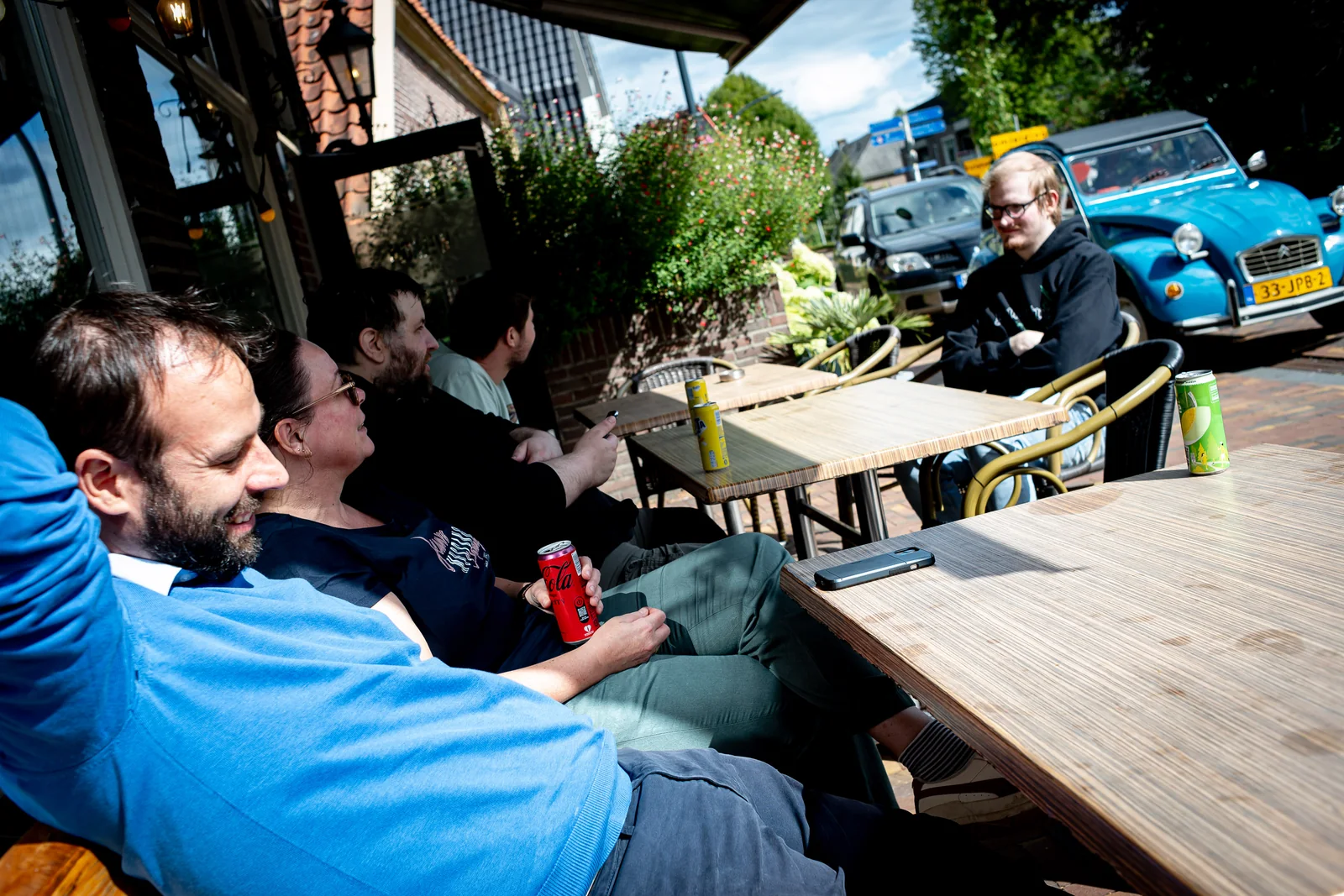 Het team ontspant op een zonnig terras, met de eendjes op de achtergrond, foto door Raymond Rothengatter
